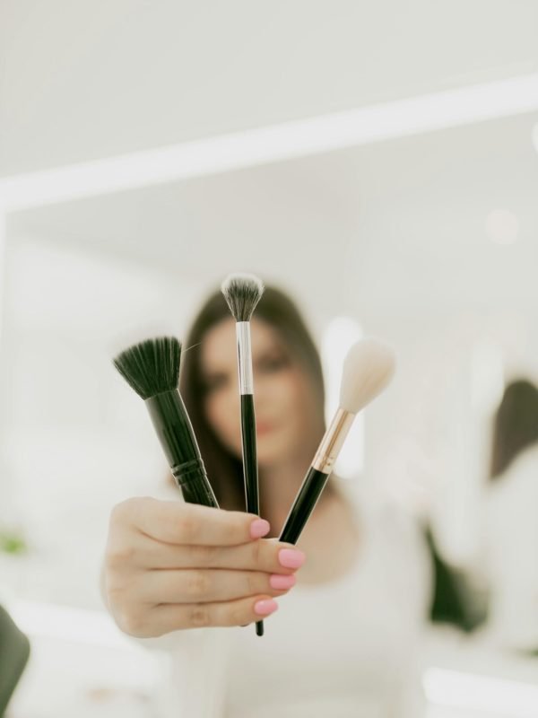 free-photo-of-woman-holding-makeup-brushes-in-modern-setting